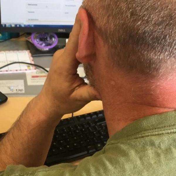 A man at a desk looking at a computer