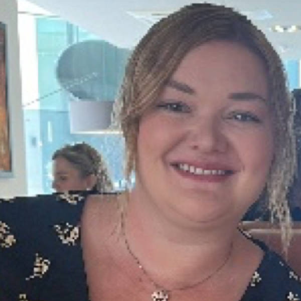 A picture of a blonde lady smiling at a camera.